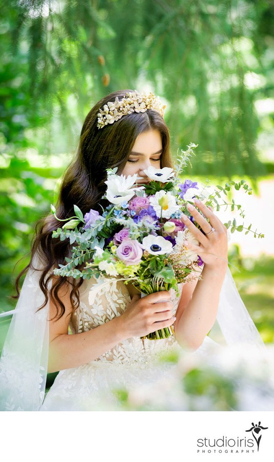 Bride in romantic lace dress in the garden with flowers