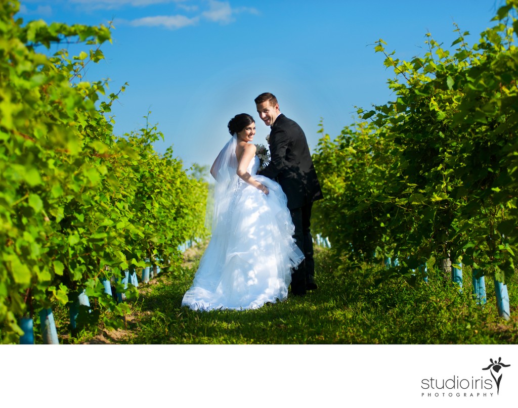 Bride and groom laughing as they run through the vineyard at Le Château Taillefer Lafon