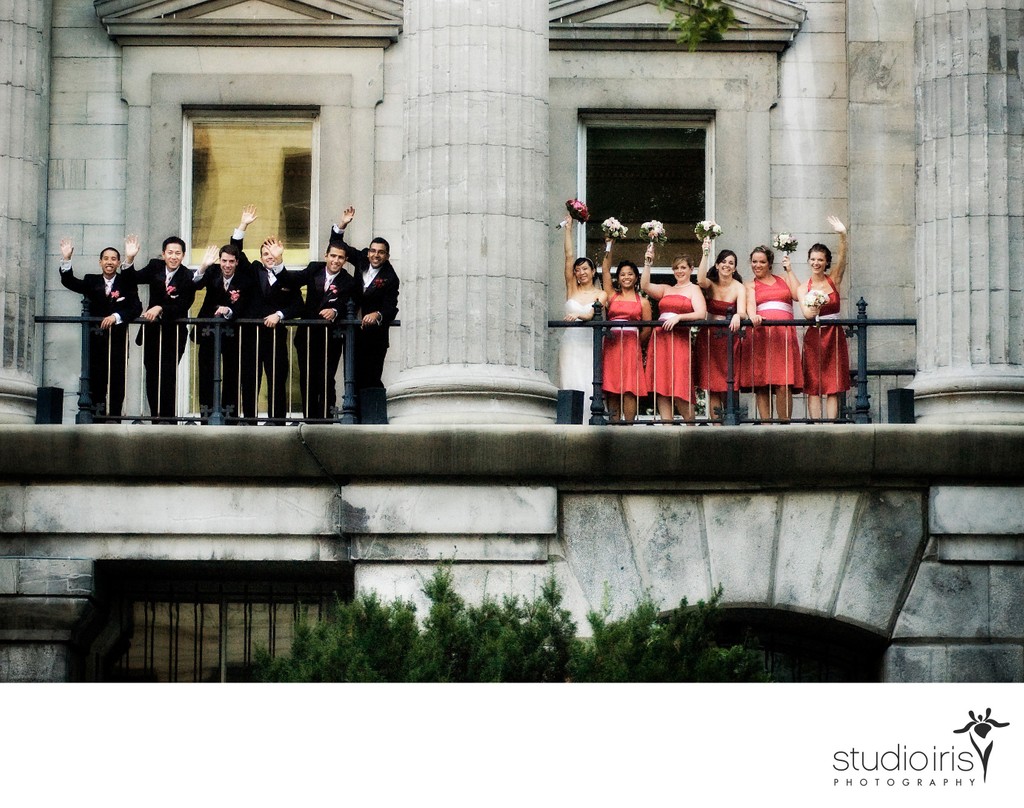 Bridal party waving from the balcony of a heritage building in Old Montreal