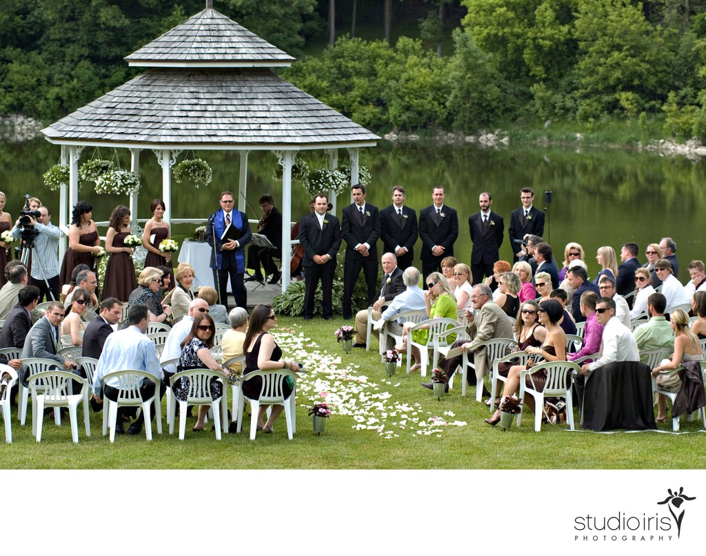 groom watching bride coming towards him at outdoor wedding ceremony a Au Vieux Moulin in Rigaud