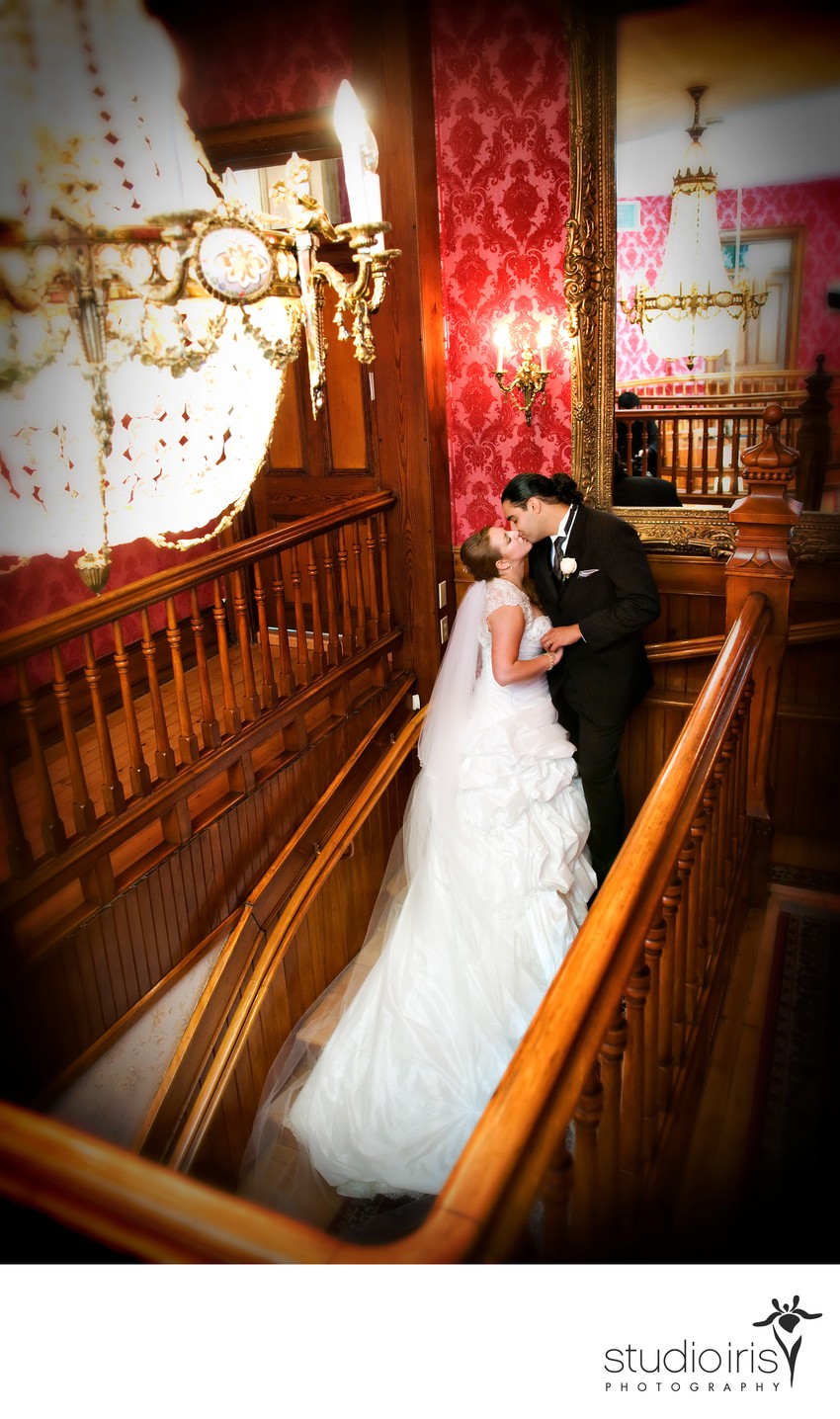 newlyweds kissing in the stairwell after their wedding at Chateau Saint Antoine