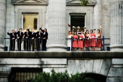 Bridal party waving from the balcony of a heritage building in Old Montreal