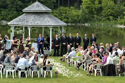 groom watching bride coming towards him at outdoor wedding ceremony a Au Vieux Moulin in Rigaud