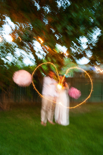 Newlyweds make a heart at dusk with a flashlight at their backyard wedding in Montreal