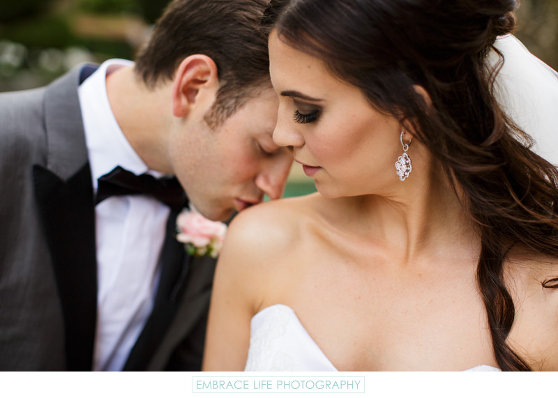 Wedding Photograph of Groom Kissing Bride's Shoulder