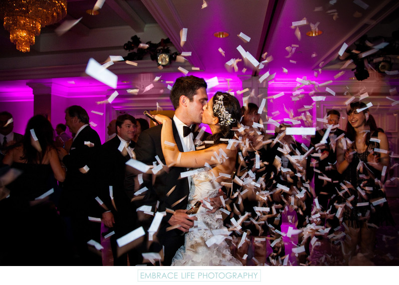 Bride & Groom Kiss Among Confetti at Wedding Reception