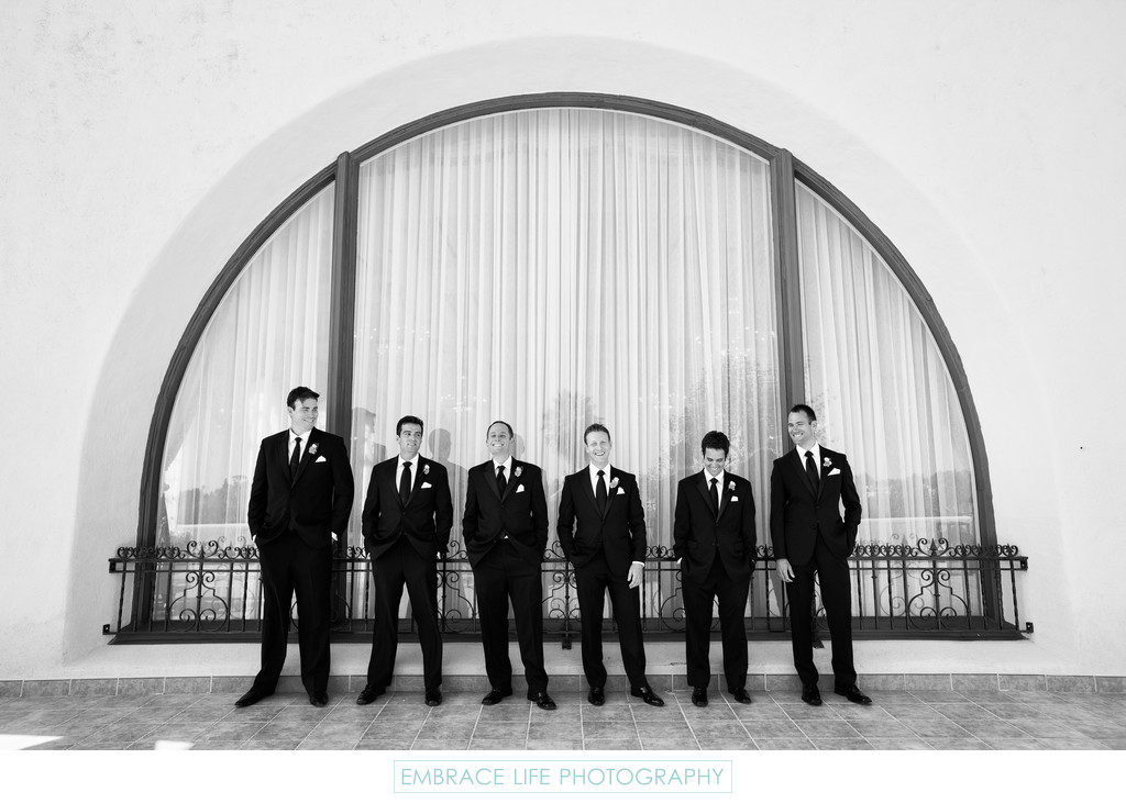 Groom and Groomsmen Pose in Front of Lg Arched Window