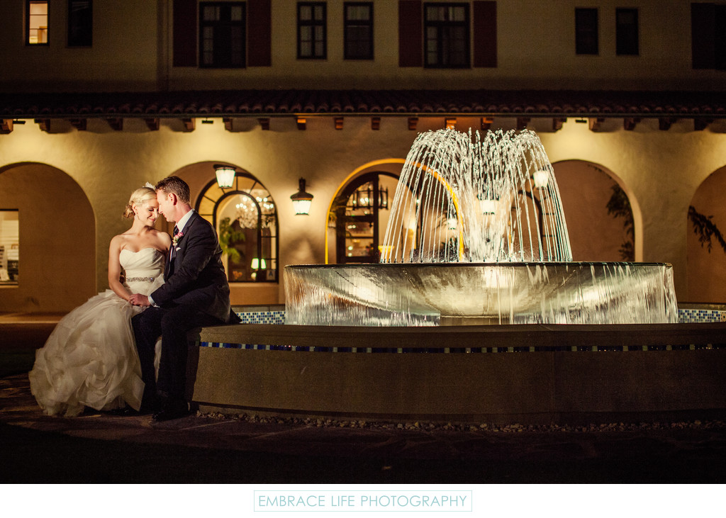 Wedding Couple Sit By Beautiful Garden Fountain