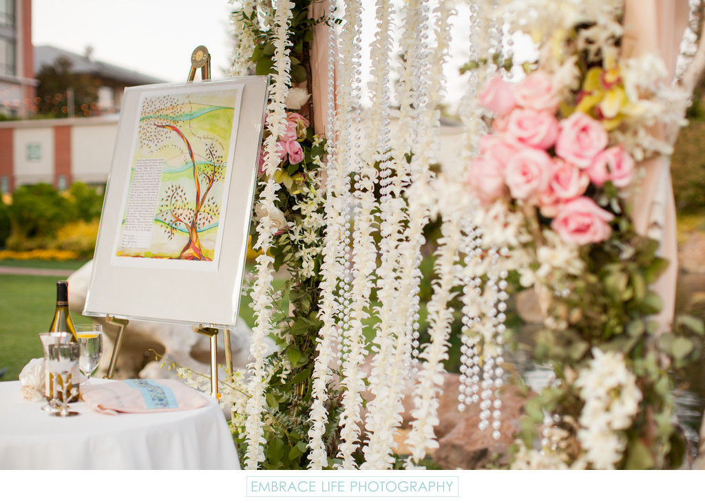 Ketubah on Easel Under Chuppah with Floral Wall