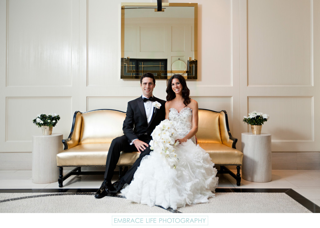 Bride and Groom Portrait in Modern Hotel on Gold Couch