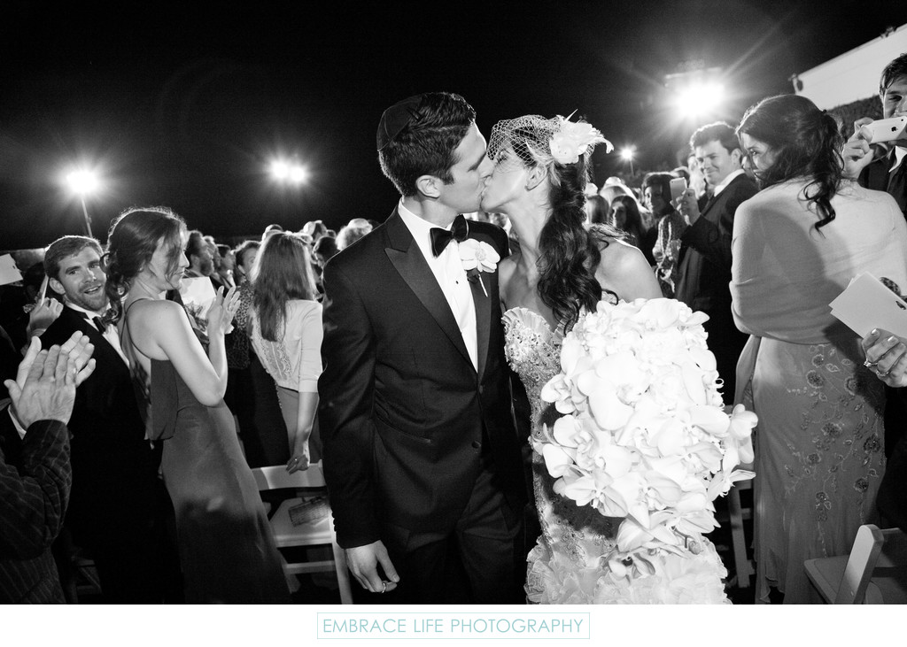 Bride and Groom Kiss During Ceremony Recessional