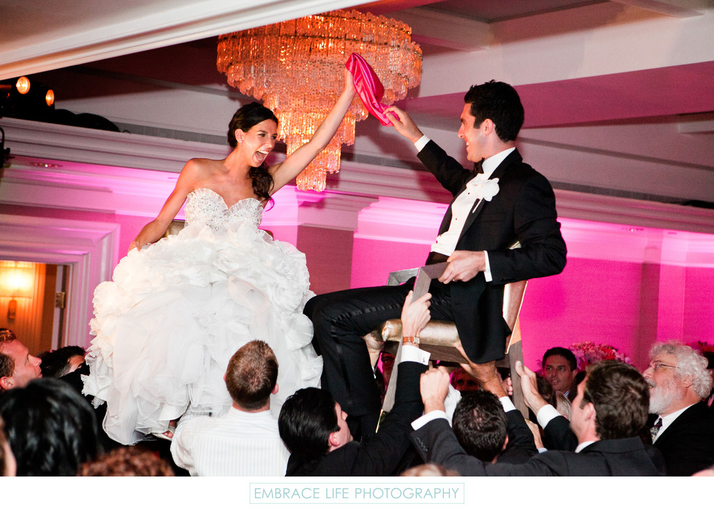 Bride & Groom in Chairs During Wedding Reception Hora
