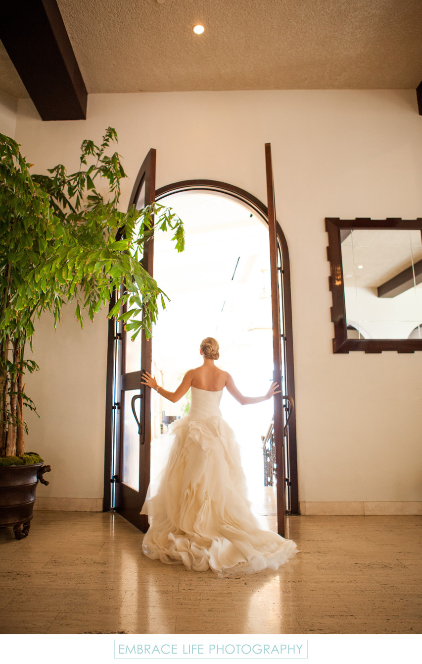 Bride Looking Out Tall Arched Doors