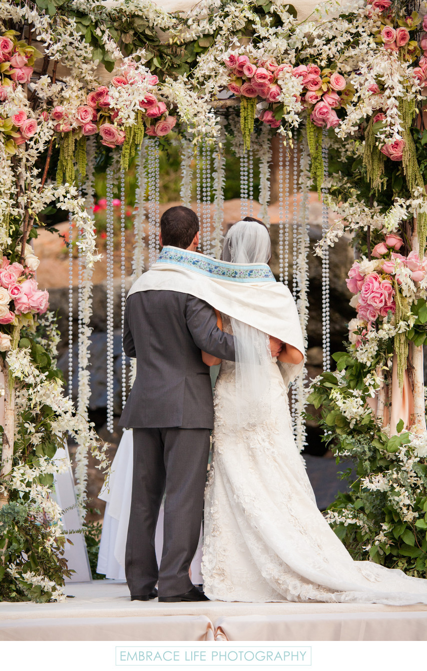 Bride and Groom Wrapped in Tallit Under the Chuppah