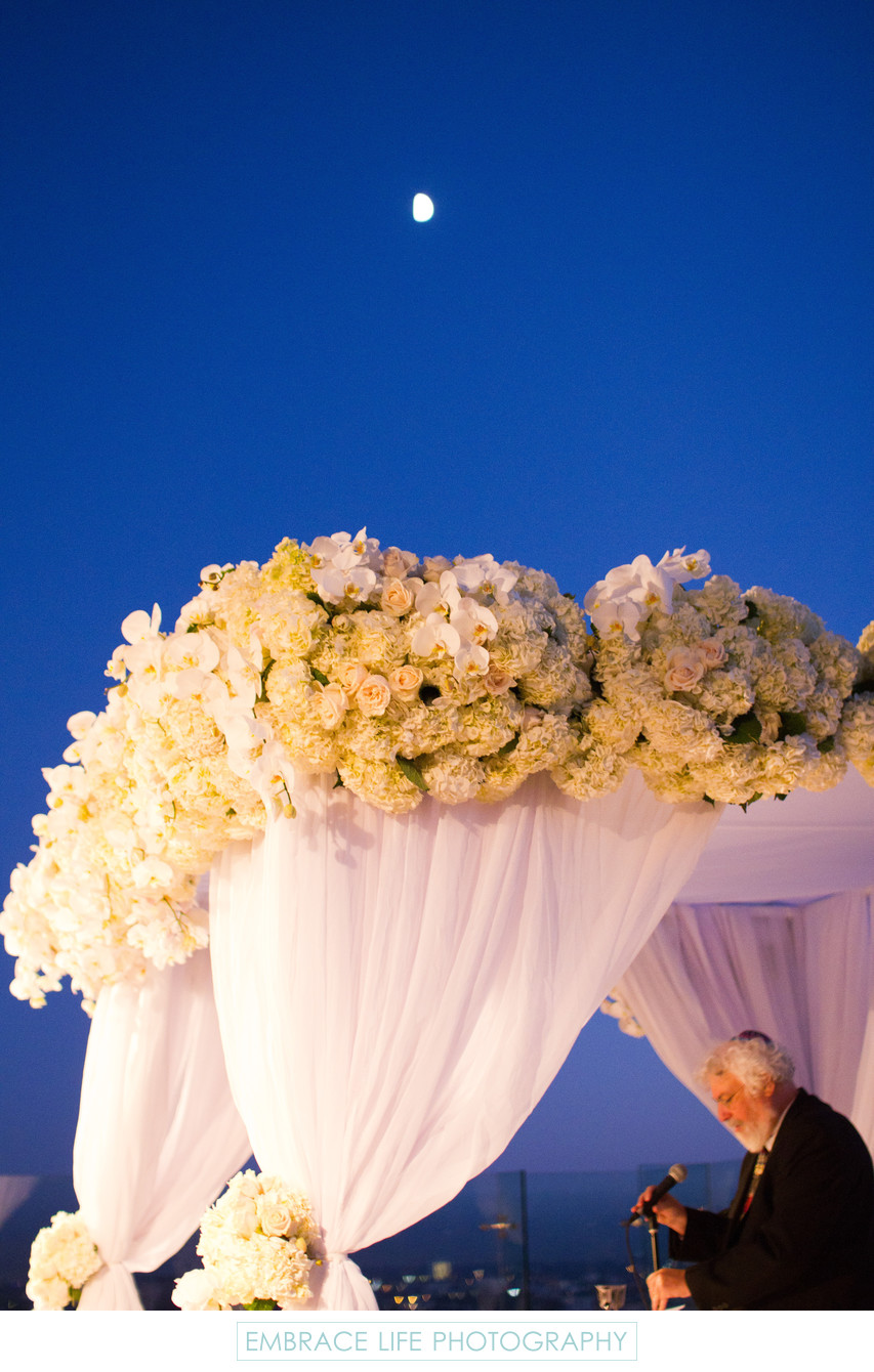 Moon Rises Above Wedding Ceremony Chuppah and Rabbi