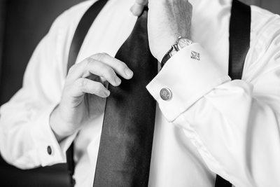 Groom Adjusting Tie With Monogrammed Cufflinks
