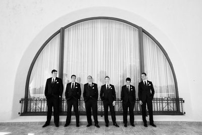 Groom and Groomsmen Pose in Front of Lg Arched Window