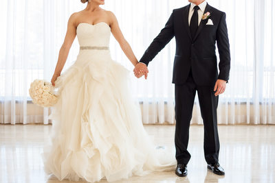 Elegantly Dressed Bride and Groom Holding Hands 
