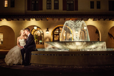 Wedding Couple Sit By Beautiful Garden Fountain