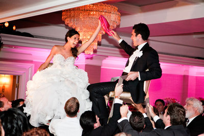 Bride & Groom in Chairs During Wedding Reception Hora