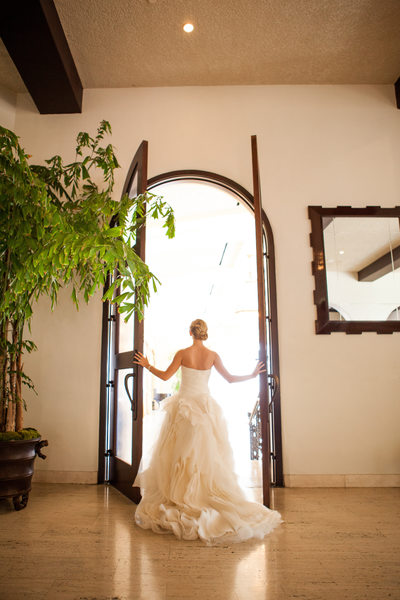 Bride Looking Out Tall Arched Doors