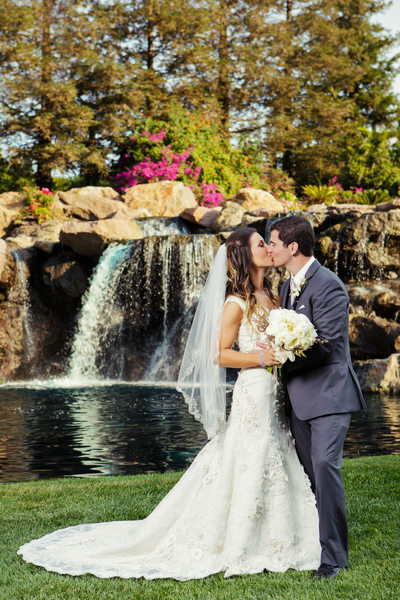 Husband and Wife kissing in Front of Waterfall