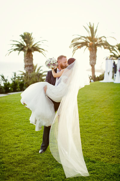 Groom Lifts Bride in His Arms for Kiss