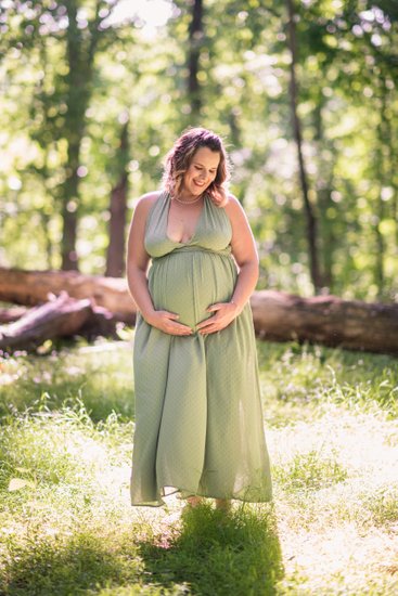 A mom-to-be poses for a summer maternity portrait. 