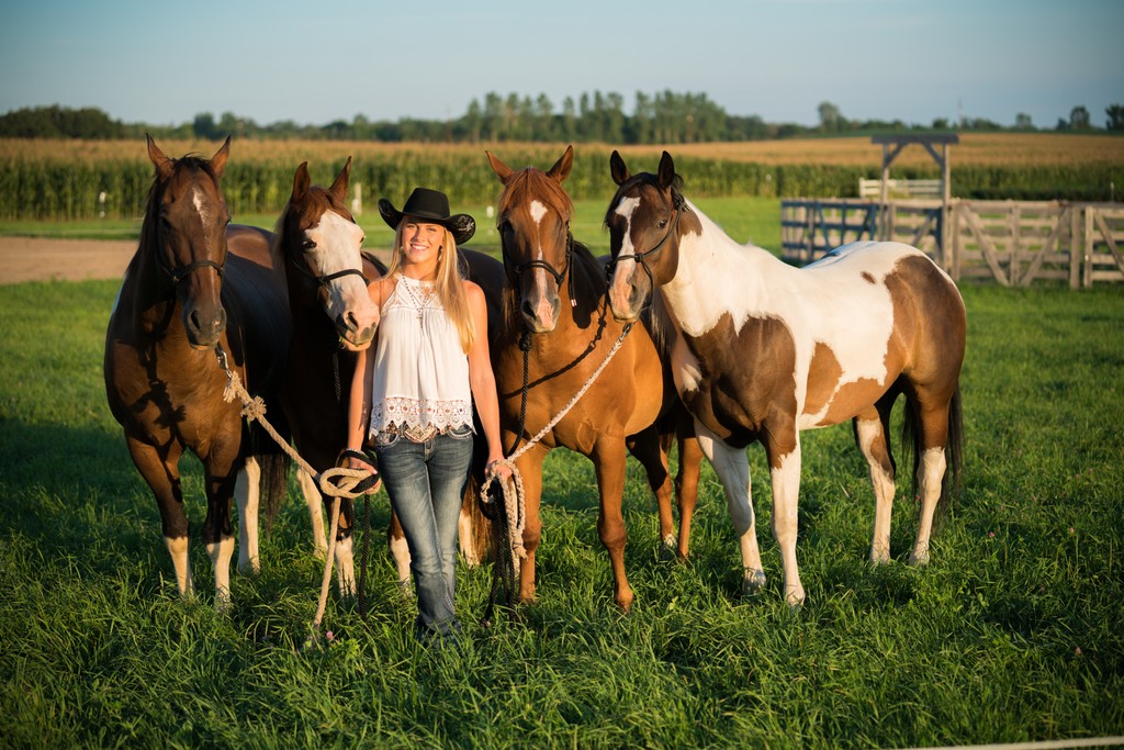 Late afternoon senior portrait with a girl and her four horses