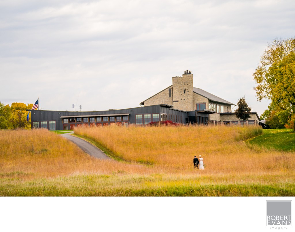 Bride & Groom walk back Hazeltine National Golf Club Club House For Their Fall Wedding