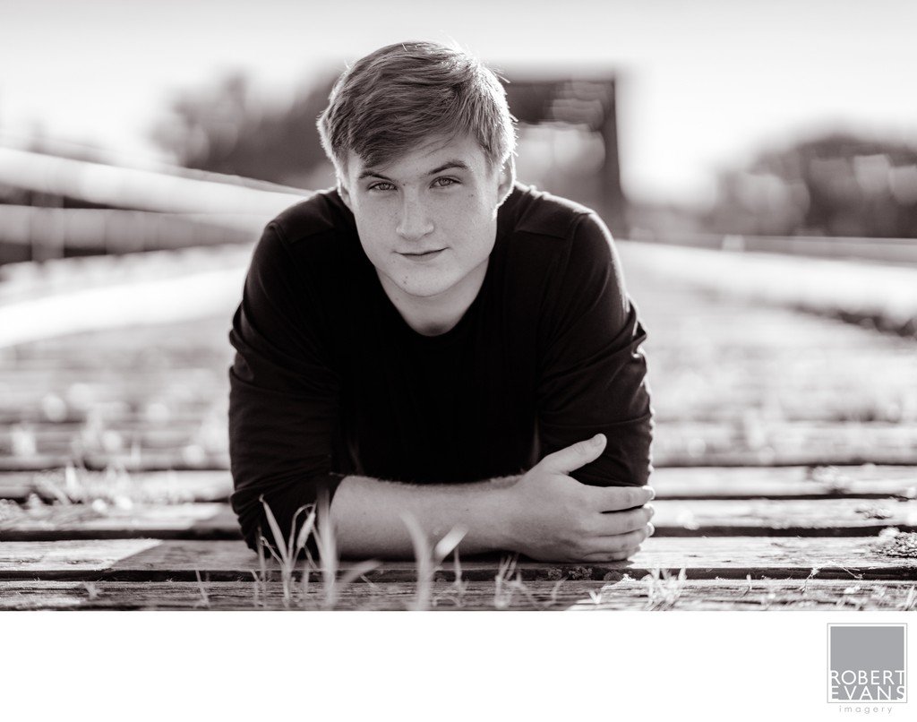 Black and White Senior Portrait of a boy on old wooden bridge