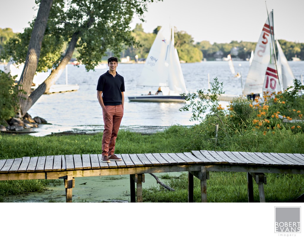 Full Body senior portrait of Wayzata High School Senior standing on a wooden foot bridge