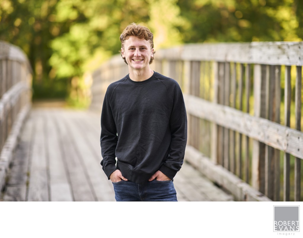 Relaxed half body senior portrait on a bridge.