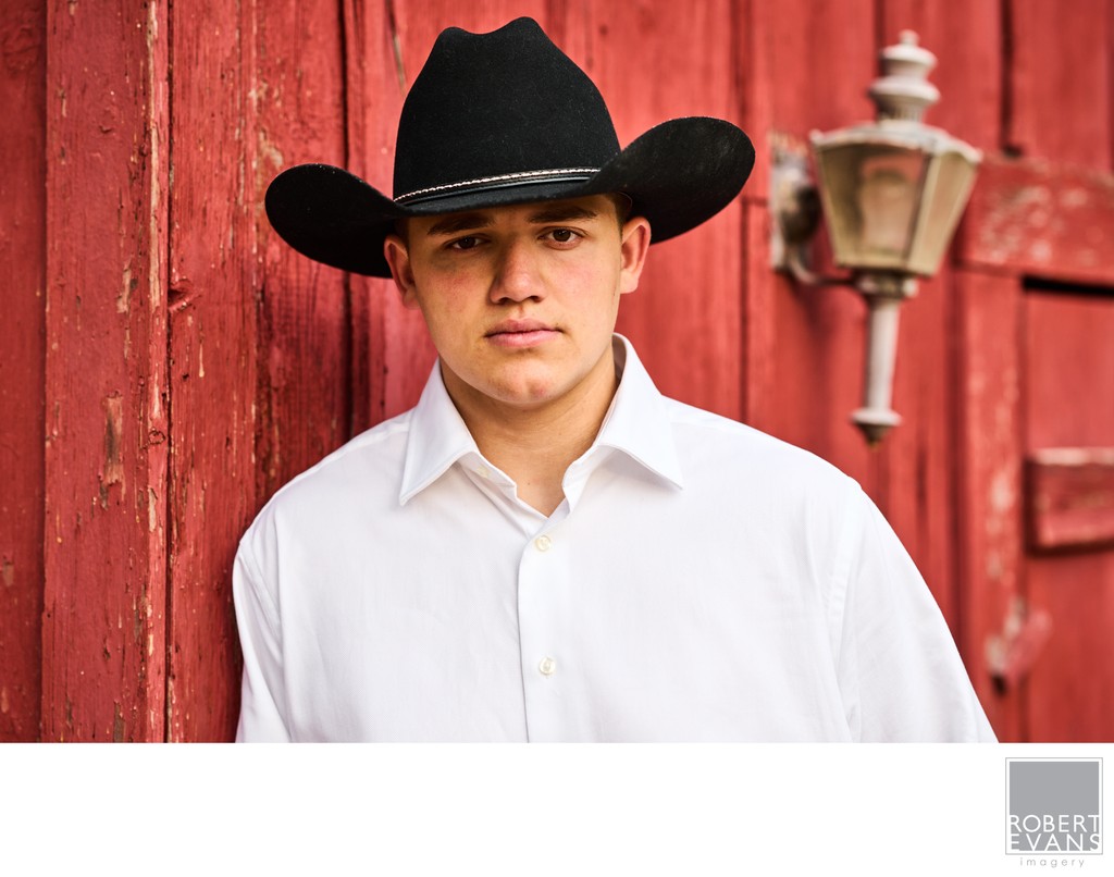 Black Cowboy Hat  Senior Senior Portrait by a Red Barn
