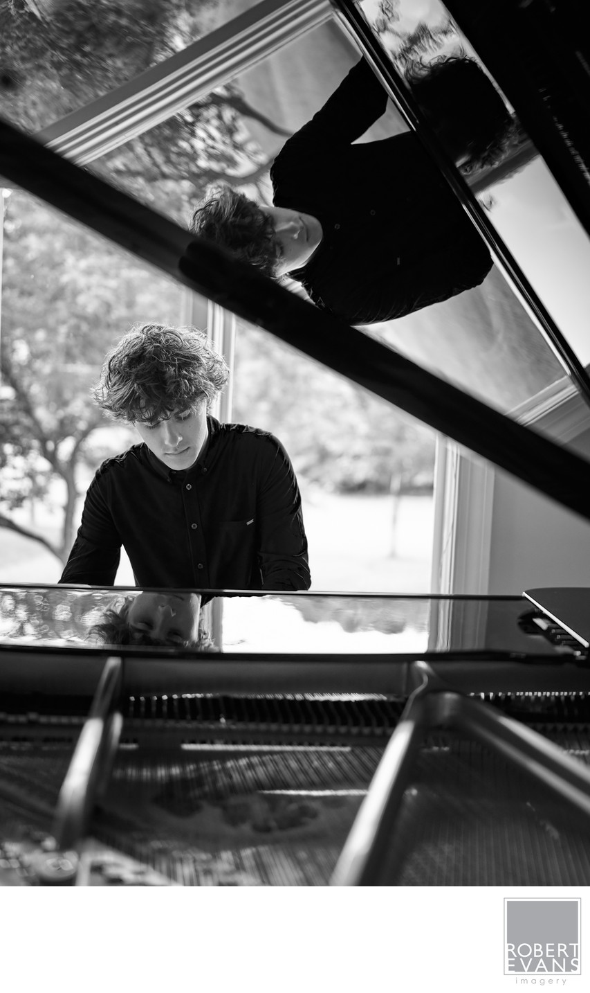Black and white portrait of a high school senior playing his piano