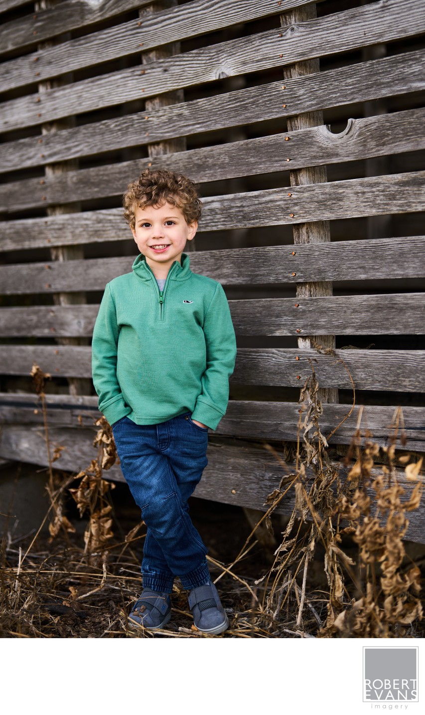 Boy against rustic wood wall