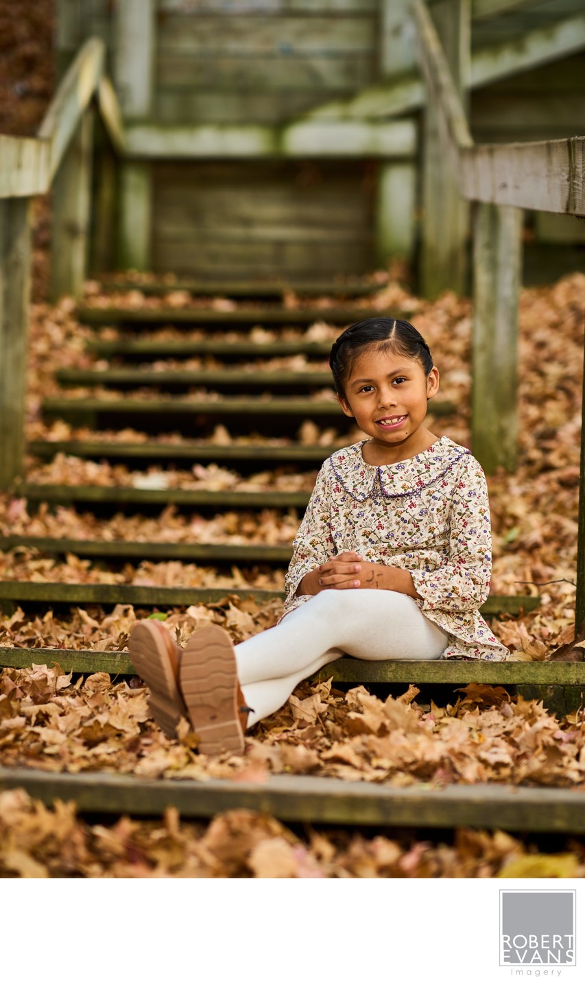 Little girl seated on wooden steps