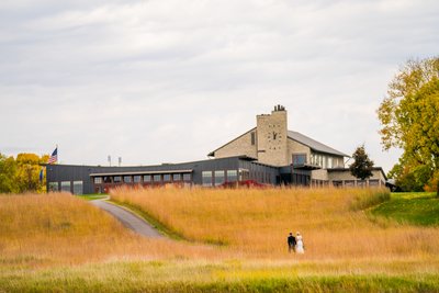 Bride & Groom walk back Hazeltine National Golf Club Club House For Their Fall Wedding