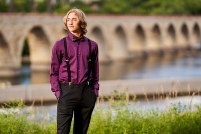 The Stone Arch Bridge in downtown Minneapolis makes striking backdrop for this boys senior portrait session