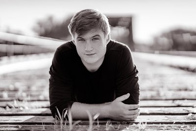 Black and White Senior Portrait of a boy on old wooden bridge