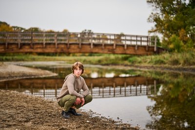 Captivating image of a high school senior next to a still creek