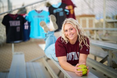 A softball senior portrait with her old softball jerseys Minnetonka Senior