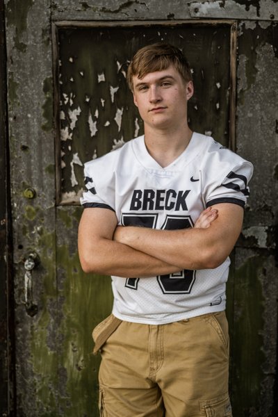 Breck High School senior portrait wearing his football Jersey