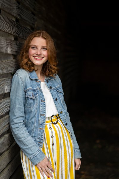 Redhead Senior Portrait In Old Wooden Structure