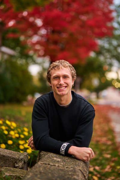 Delano Senior portrait with stunning bright red backdrop