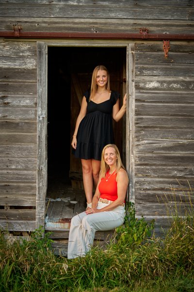 Southwest Christian Senior with her mom in the doorway of and old barn.
