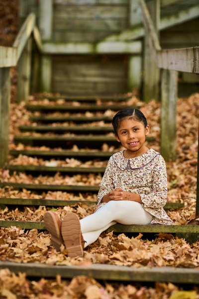 Little girl seated on wooden steps