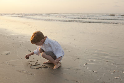  Portrait of a boy writing in the sand, Ocean Isle Beach NC
