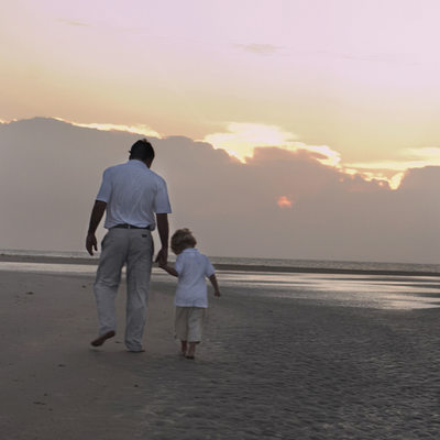 Father and son walking on the beach at Sunset Beach, NC