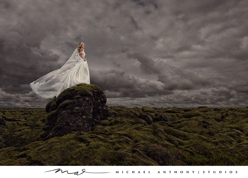 Bride Stands on Rock in dramatic bridal portrait